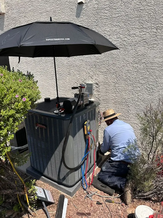 HVAC technician performing outdoor AC maintenance in Wilmer
